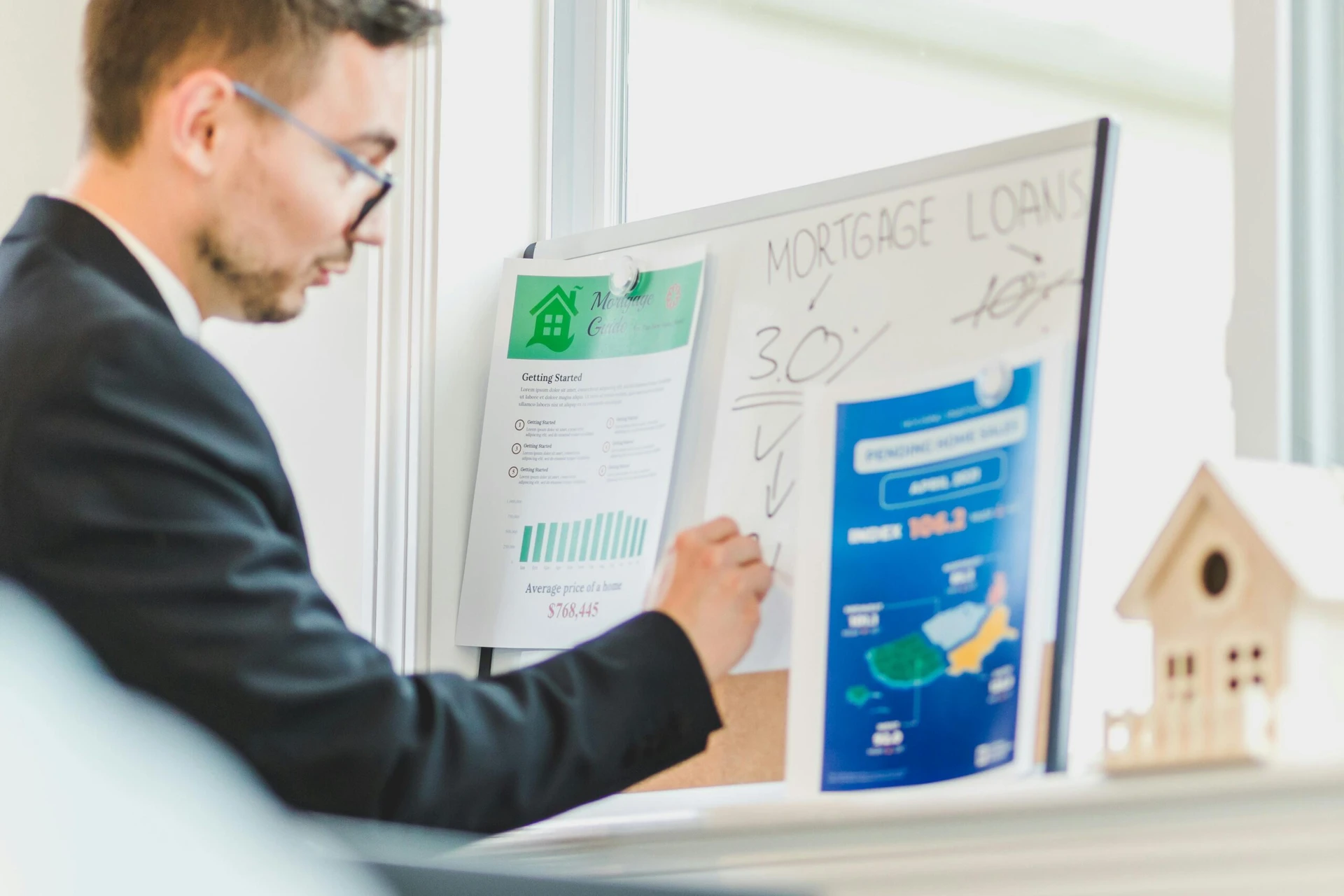 Mortgage advisor explaining loan details using charts and documents on a whiteboard.
